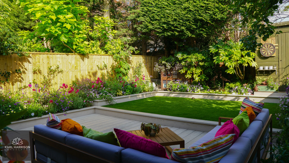 Идея дизайна: солнечный, летний регулярный сад среднего размера на заднем дворе в стиле модернизм с высокими грядками, хорошей освещенностью, настилом и с деревянным забором