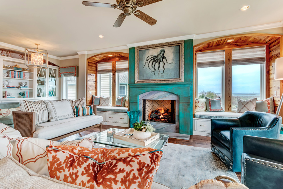 This is an example of a large beach style living room in Wilmington with beige walls, medium hardwood floors, a standard fireplace, a stone fireplace surround and brown floor.