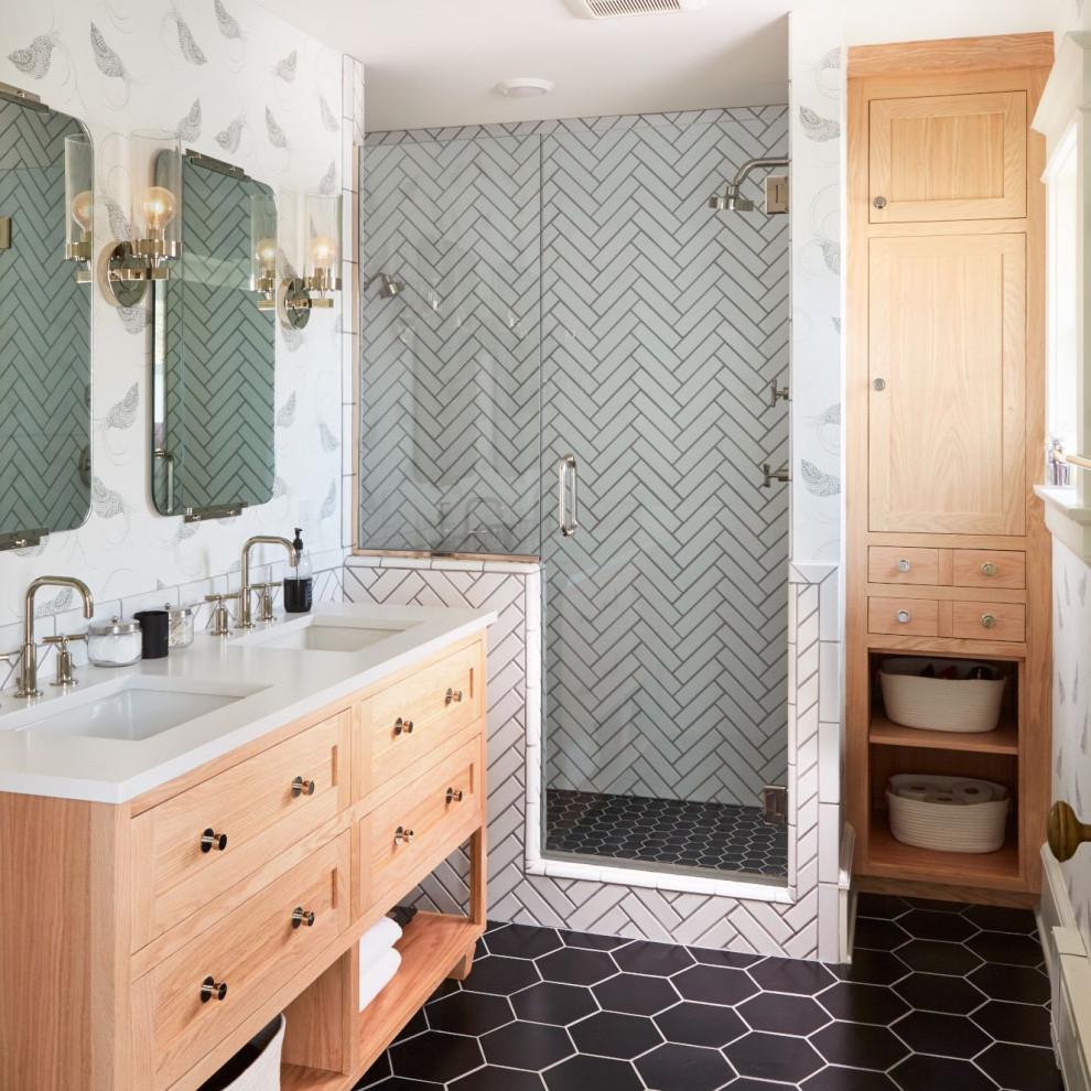 Inspiration for a transitional bathroom in Minneapolis with flat-panel cabinets, light wood cabinets, an alcove shower, white tile, white walls, an undermount sink, black floor, a hinged shower door, white benchtops, a double vanity, a freestanding vanity and wallpaper.