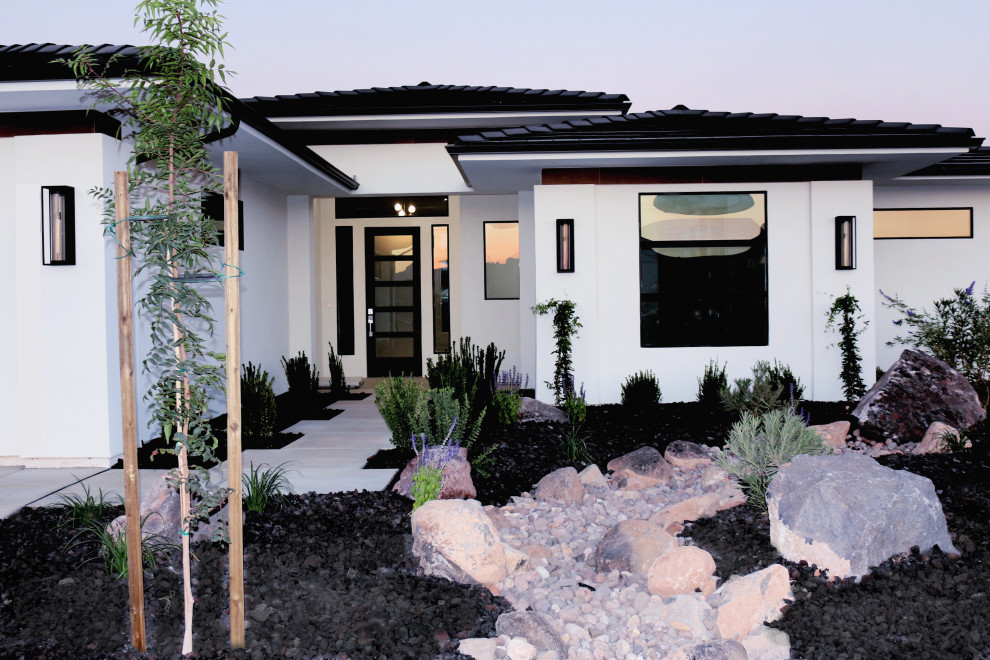 Idée de décoration pour une façade de maison blanche minimaliste en stuc de plain-pied avec un toit à quatre pans, un toit en tuile et un toit noir.