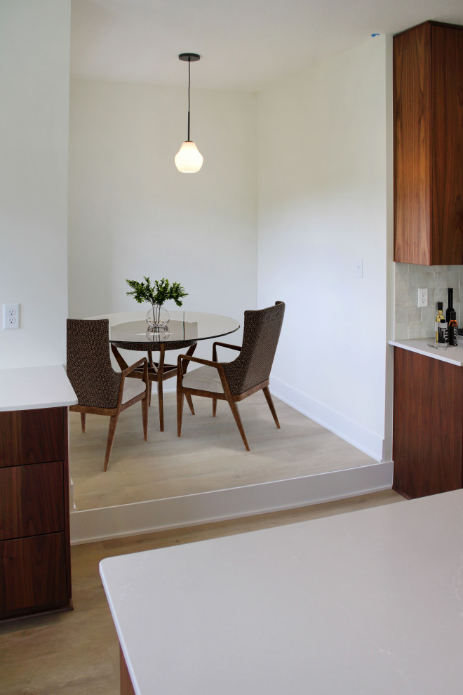 Foto di un piccolo angolo colazione con pareti bianche, pavimento in legno massello medio e pavimento marrone