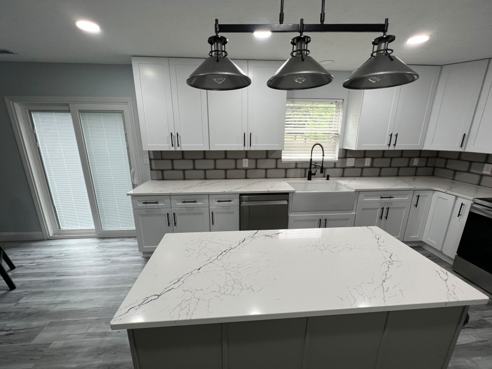 Mid-sized trendy l-shaped eat-in kitchen photo in Indianapolis with shaker cabinets, white cabinets, quartz countertops, an island and white countertops