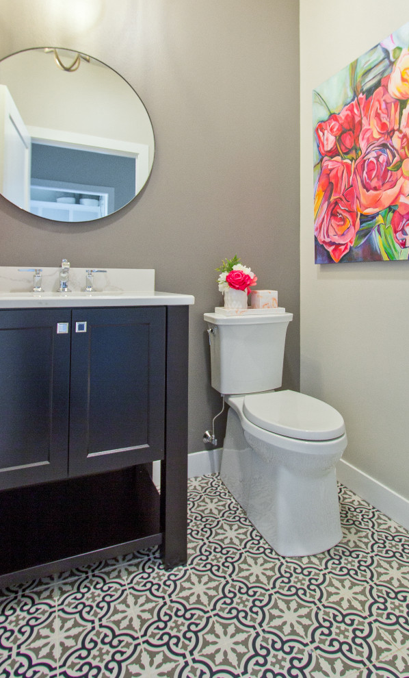 This is an example of a transitional powder room in Other with recessed-panel cabinets, dark wood cabinets, porcelain floors, an undermount sink, engineered quartz benchtops, multi-coloured floor, white benchtops and a freestanding vanity.