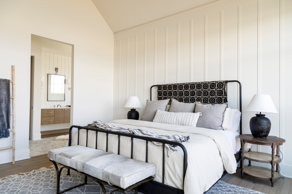 Mittelgroßes Landhausstil Hauptschlafzimmer mit weißer Wandfarbe, braunem Holzboden, Kamin, verputzter Kaminumrandung, gewölbter Decke und Wandpaneelen in Boise