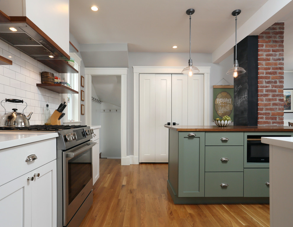 Small contemporary u-shaped kitchen in Boston with an undermount sink, shaker cabinets, green cabinets, wood benchtops, white splashback, subway tile splashback, stainless steel appliances, medium hardwood floors and with island.