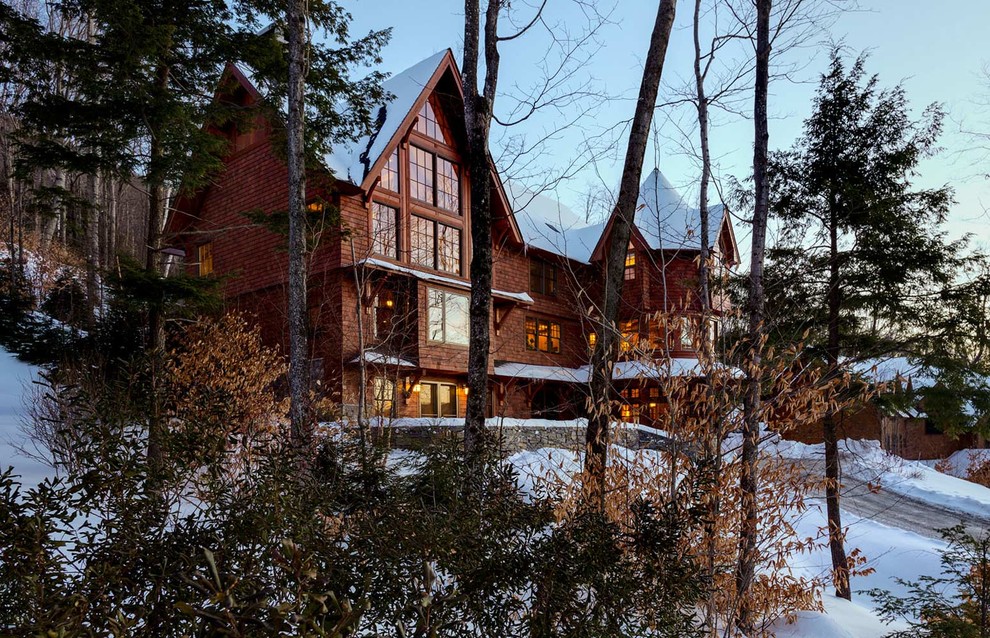 Large mountain style brown three-story wood exterior home photo in Burlington