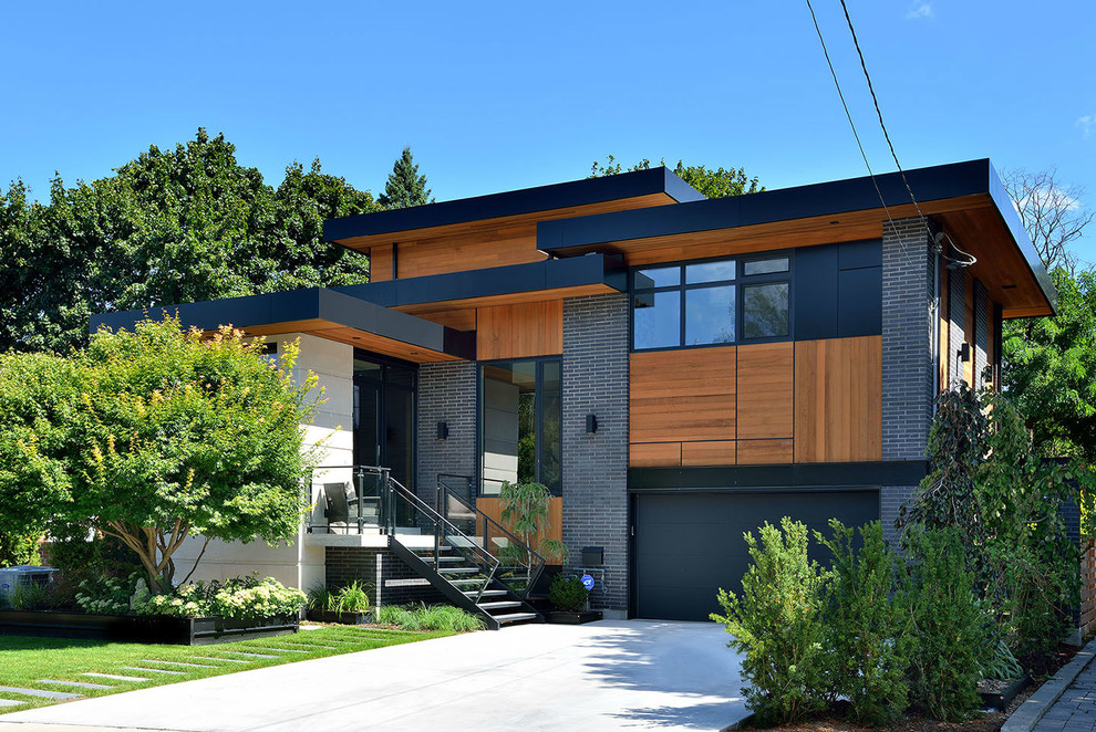 Design ideas for a large contemporary two-storey grey exterior in Toronto with mixed siding and a flat roof.