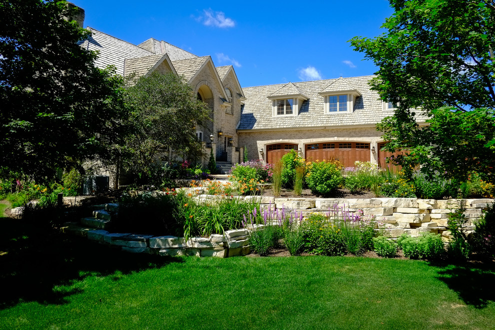 Inspiration for a large traditional front yard full sun xeriscape for summer in Milwaukee with natural stone pavers and a garden path.