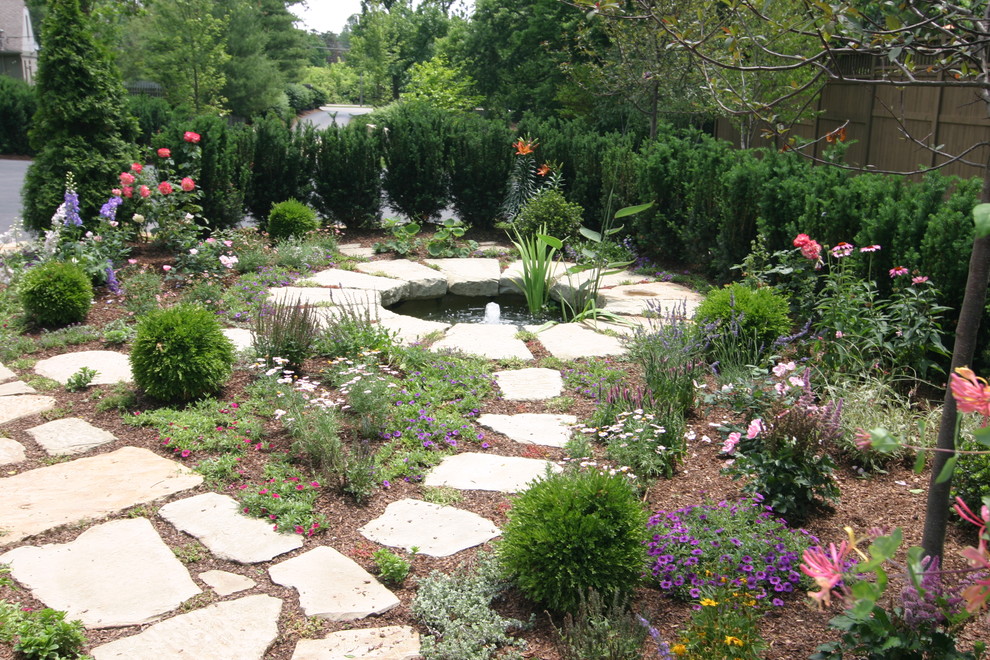 Inspiration for a large traditional backyard full sun garden in Orange County with with pond and natural stone pavers.