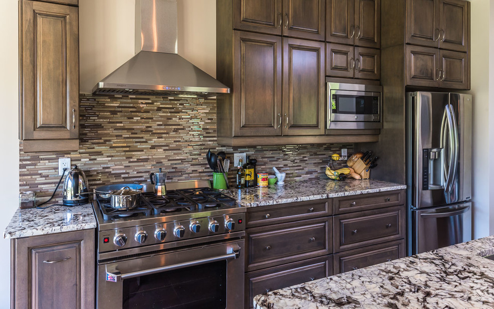 Open concept kitchen - transitional open concept kitchen idea in Toronto with a double-bowl sink, raised-panel cabinets, dark wood cabinets, marble countertops, multicolored backsplash, matchstick tile backsplash, stainless steel appliances and an island