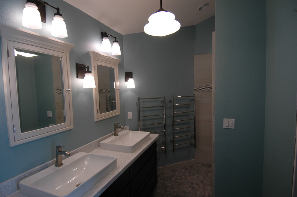 Photo of a mid-sized contemporary master bathroom in Sacramento with recessed-panel cabinets, black cabinets, a curbless shower, a wall-mount toilet, multi-coloured tile, porcelain tile, blue walls, pebble tile floors, a vessel sink and recycled glass benchtops.