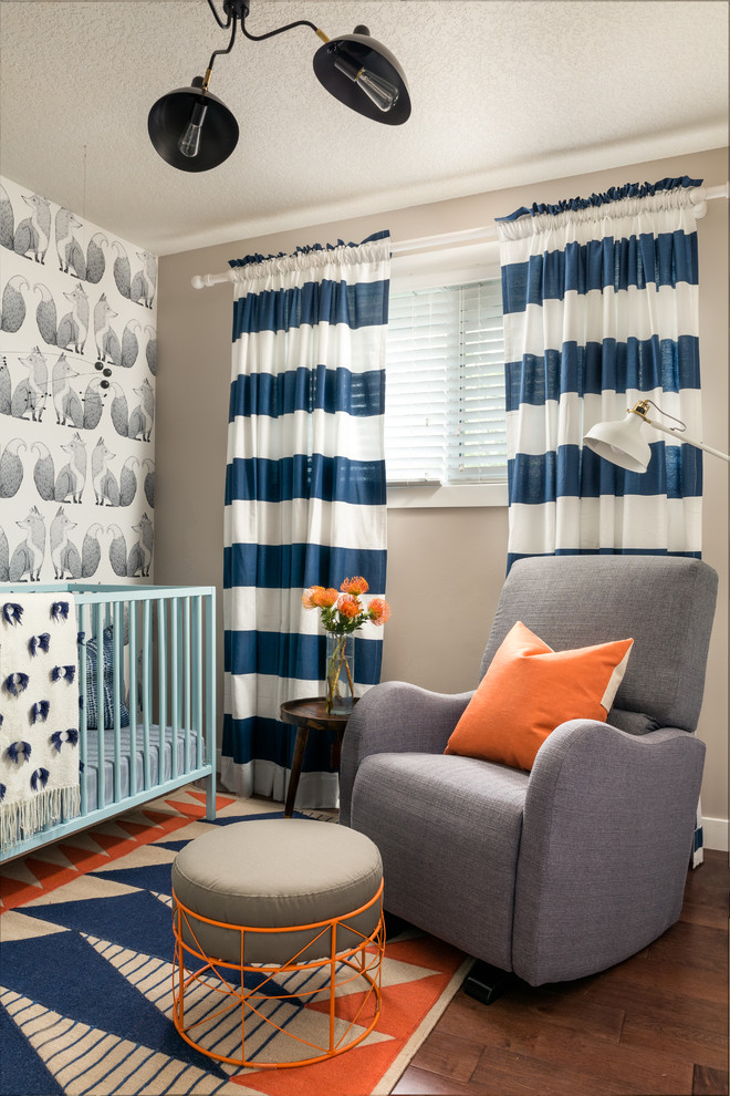Photo of a transitional gender-neutral nursery in Calgary with multi-coloured walls and dark hardwood floors.