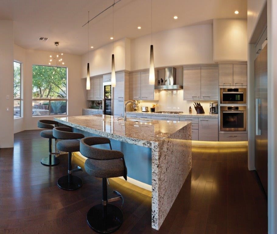 Open concept kitchen - large contemporary galley medium tone wood floor open concept kitchen idea in Phoenix with flat-panel cabinets, gray cabinets, granite countertops, white backsplash, glass sheet backsplash, stainless steel appliances, gray walls and an island