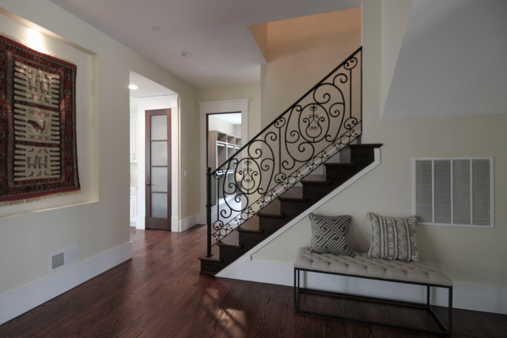 Design ideas for an expansive transitional wood curved staircase in DC Metro with wood risers and metal railing.
