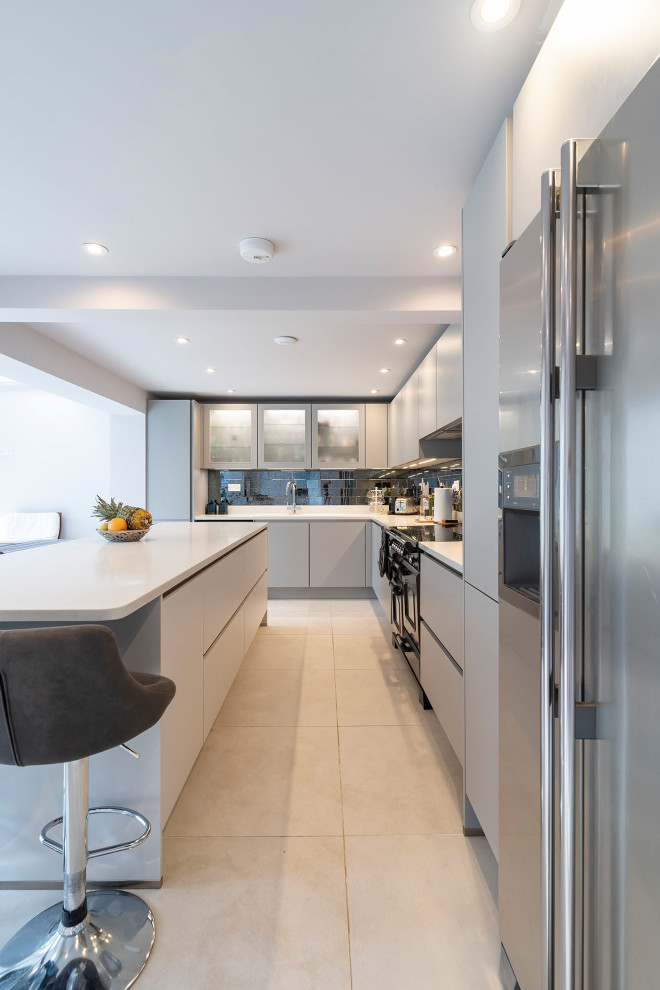 Photo of a large modern l-shaped open plan kitchen in Oxfordshire with flat-panel cabinets, grey cabinets, quartz worktops, stainless steel appliances, an island, white worktops and exposed beams.