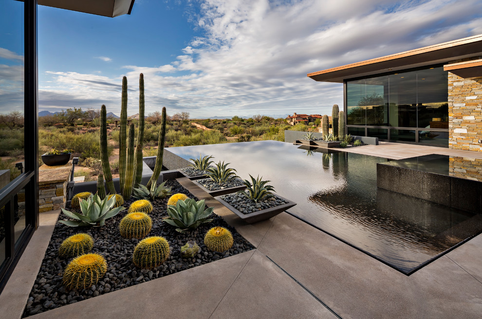 Design ideas for a large backyard rectangular infinity pool in Phoenix with a hot tub and concrete slab.
