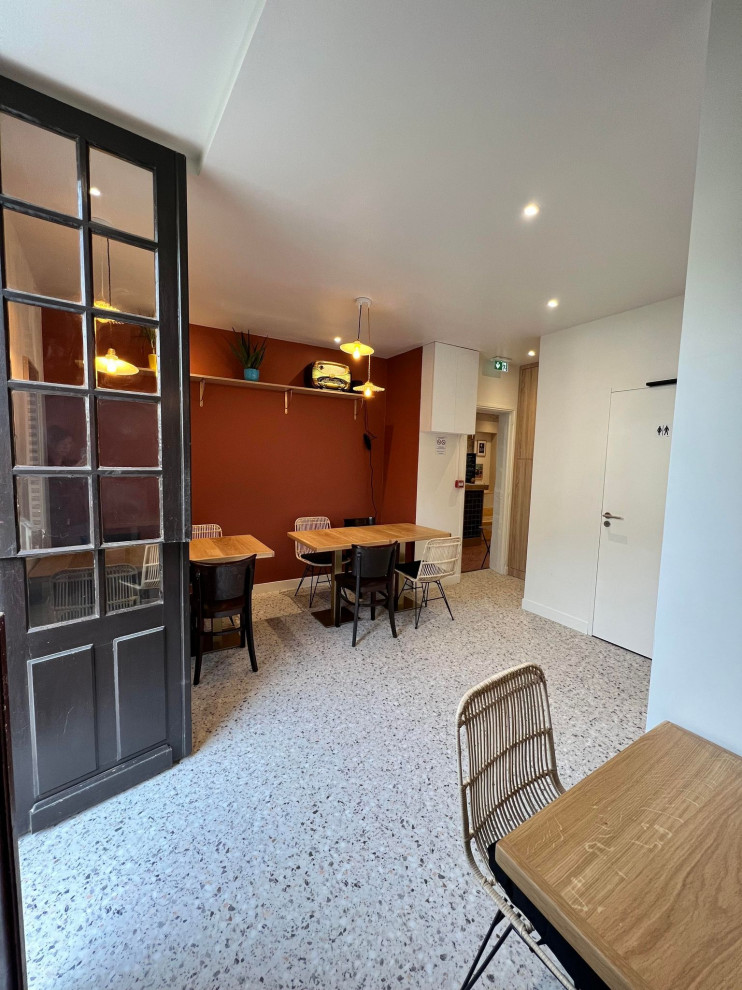 Foto di una sala da pranzo aperta verso il soggiorno di medie dimensioni con pareti rosse, pavimento in vinile e nessun camino