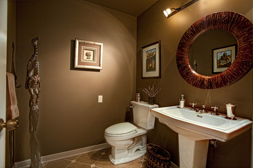 This is an example of an eclectic bathroom in Seattle with a pedestal sink, a two-piece toilet, beige tile, porcelain tile, brown walls and porcelain floors.