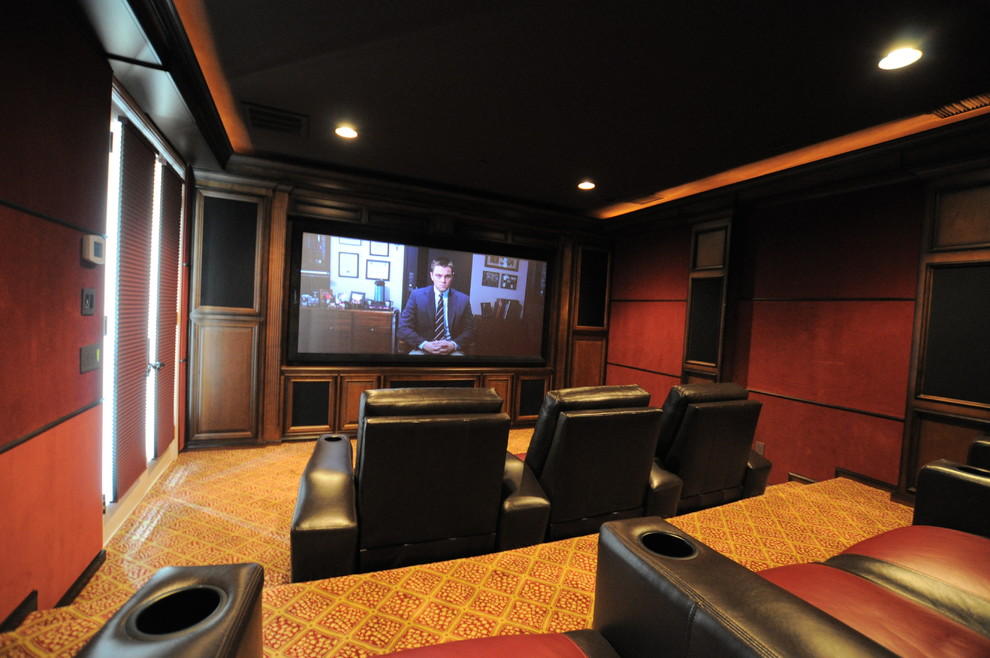 Photo of a large transitional enclosed home theatre in Los Angeles with red walls, carpet, a projector screen and yellow floor.