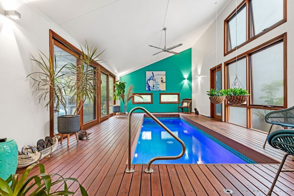 Photo of a large contemporary backyard rectangular lap pool in Adelaide with a pool house and decking.
