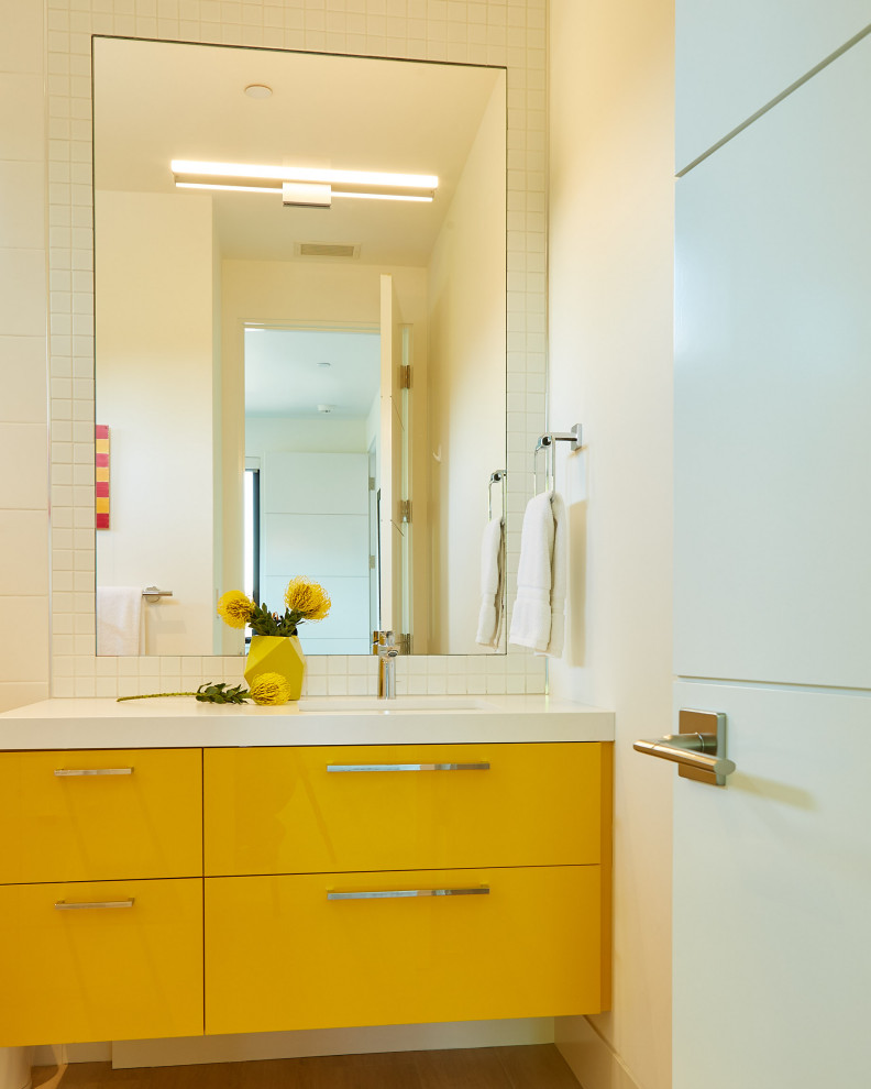 Small contemporary kids bathroom in San Francisco with flat-panel cabinets, yellow cabinets, white tile, ceramic tile, engineered quartz benchtops and white benchtops.