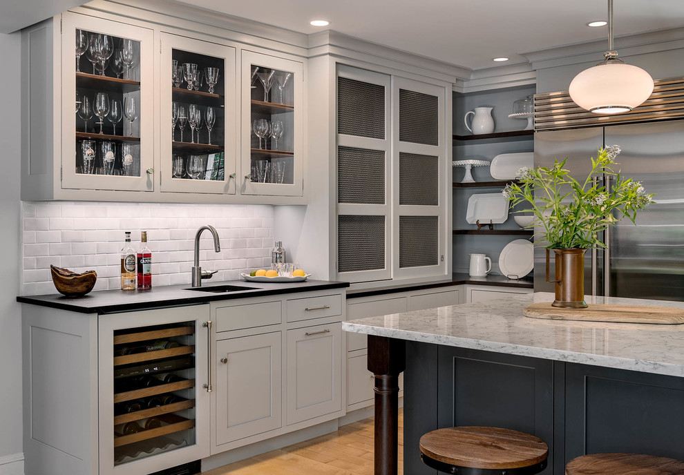 This is an example of a large transitional u-shaped eat-in kitchen in Boston with an undermount sink, recessed-panel cabinets, grey cabinets, soapstone benchtops, grey splashback, subway tile splashback, stainless steel appliances, medium hardwood floors, with island, beige floor and green benchtop.
