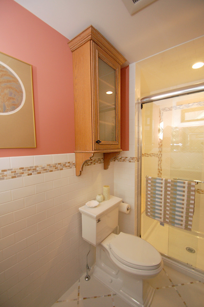 Small traditional 3/4 bathroom in Newark with an alcove shower, a one-piece toilet, white tile, subway tile, mosaic tile floors, an undermount sink, raised-panel cabinets, light wood cabinets, pink walls and granite benchtops.