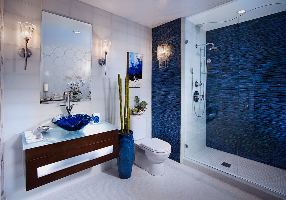 Mid-sized contemporary master bathroom in Orange County with flat-panel cabinets, dark wood cabinets, an alcove shower, a two-piece toilet, grey walls, mosaic tile floors, a vessel sink, glass benchtops, white floor, a hinged shower door, blue tile, glass tile and white benchtops.