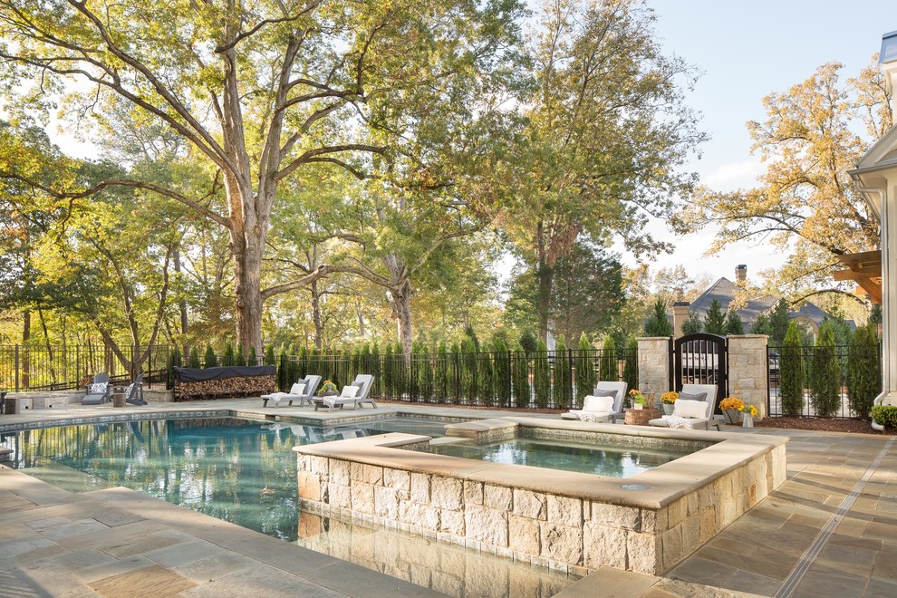 Design ideas for a large country backyard custom-shaped natural pool in Atlanta with a hot tub and natural stone pavers.