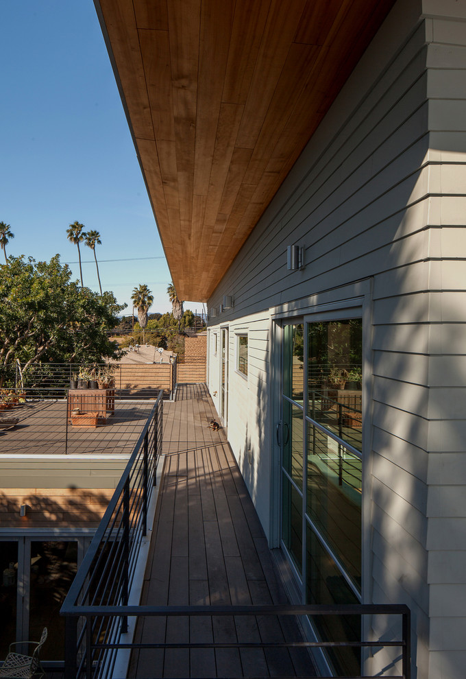 Design ideas for a mid-sized beach style rooftop deck in Los Angeles with a roof extension.