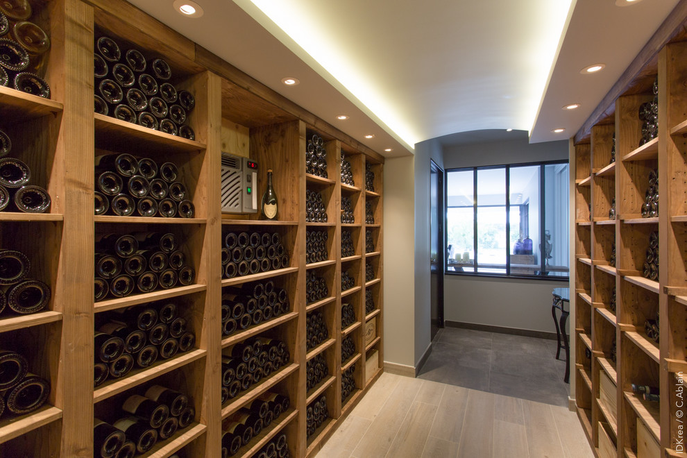 This is an example of a large industrial wine cellar in Paris with ceramic floors, storage racks and brown floor.