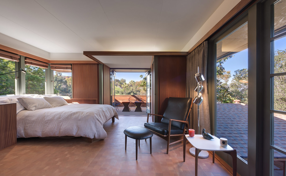 This is an example of a large midcentury master bedroom in Los Angeles with medium hardwood floors, white walls and brown floor.