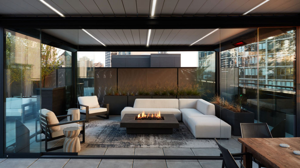 Foto di una terrazza minimalista sul tetto e sul tetto con una pergola e un focolare