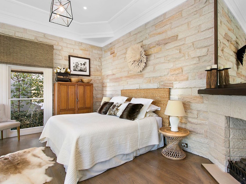 Design ideas for a transitional bedroom in Sydney with dark hardwood floors, a corner fireplace, a stone fireplace surround and brown floor.