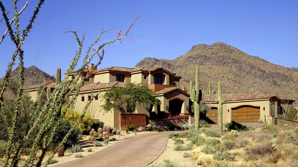 This is an example of an expansive two-storey adobe beige exterior in Phoenix.