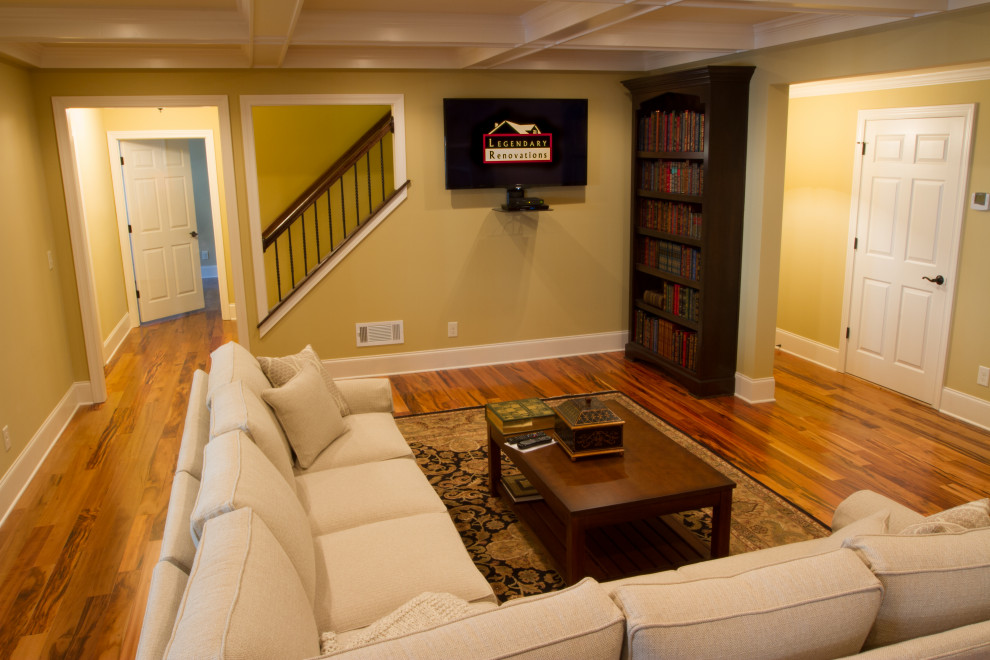 This is an example of a large contemporary walk-out basement in Atlanta with light hardwood floors and coffered.