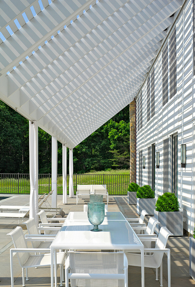 Photo of a modern patio in Richmond with a pergola and natural stone pavers.