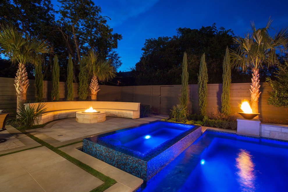 Inspiration for a large transitional backyard custom-shaped pool in Dallas with natural stone pavers.