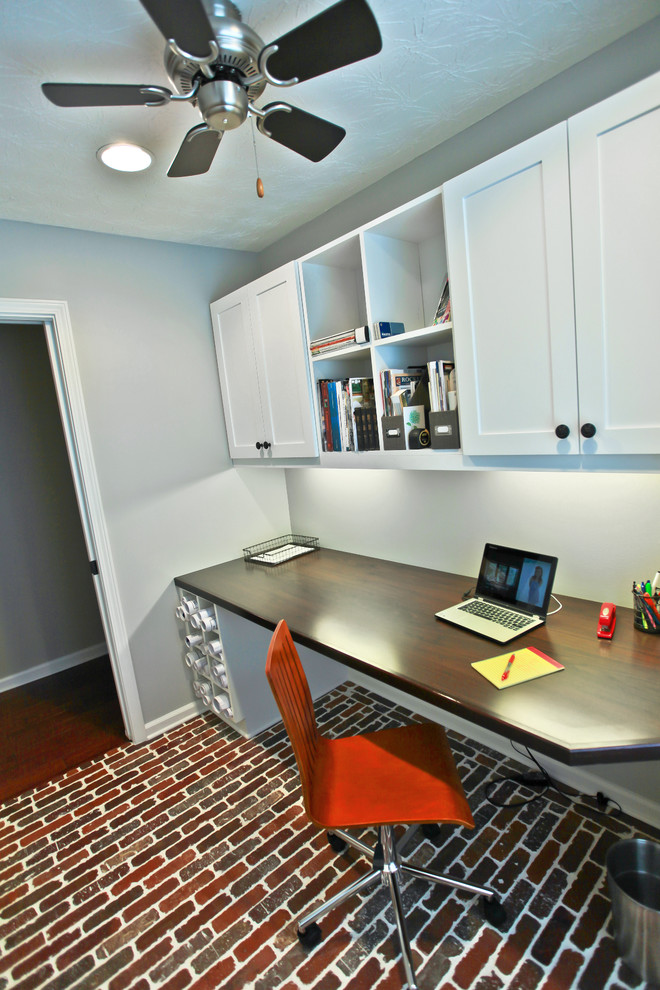 Small arts and crafts home office in Atlanta with brick floors and a built-in desk.