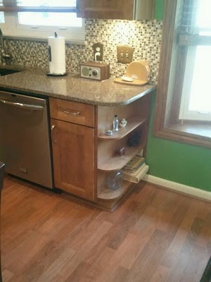 Example of a mid-sized transitional u-shaped medium tone wood floor eat-in kitchen design in Cincinnati with an undermount sink, flat-panel cabinets, medium tone wood cabinets, quartz countertops, multicolored backsplash, mosaic tile backsplash, stainless steel appliances and an island