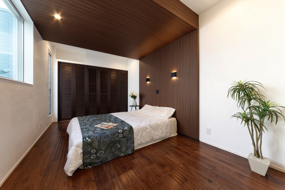 Master bedroom in Other with white walls, dark hardwood floors, brown floor, wallpaper and planked wall panelling.