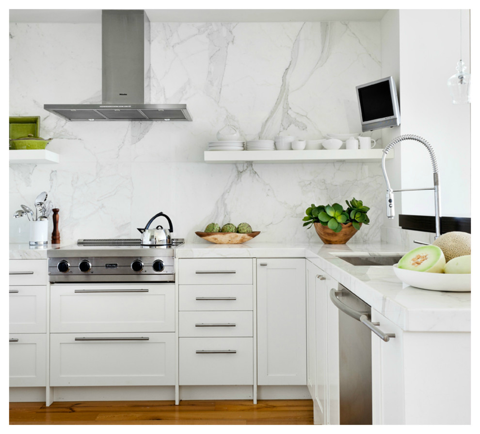 Foto på ett mellanstort funkis kök, med skåp i shakerstil, vita skåp, marmorbänkskiva, vitt stänkskydd, stänkskydd i sten, rostfria vitvaror, en halv köksö, en enkel diskho och ljust trägolv