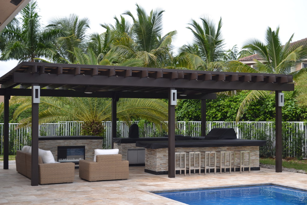 Expansive mediterranean backyard patio in Miami with an outdoor kitchen, natural stone pavers and a gazebo/cabana.