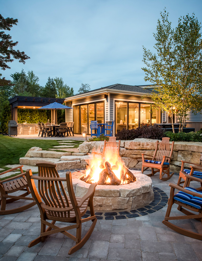 This is an example of a traditional backyard patio in Other with an outdoor kitchen, brick pavers and a pergola.