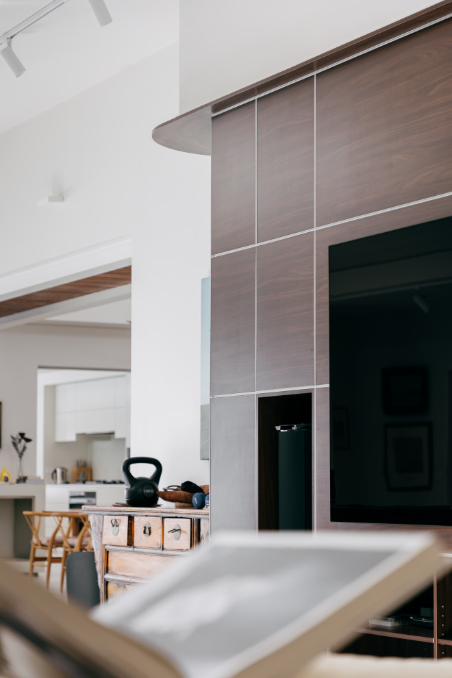 Foto di un ampio soggiorno minimalista stile loft con libreria, pareti marroni, pavimento in gres porcellanato, parete attrezzata e pavimento grigio