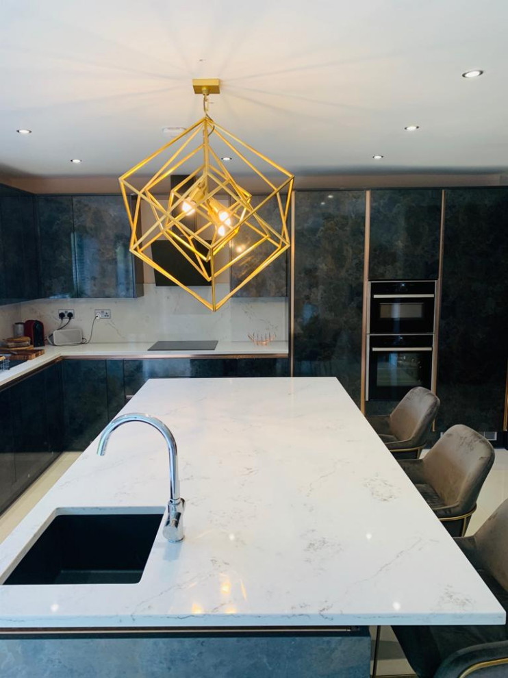 Mid-sized contemporary l-shaped eat-in kitchen in London with a drop-in sink, flat-panel cabinets, distressed cabinets, quartzite benchtops, yellow splashback, engineered quartz splashback, panelled appliances, ceramic floors, with island, beige floor and white benchtop.