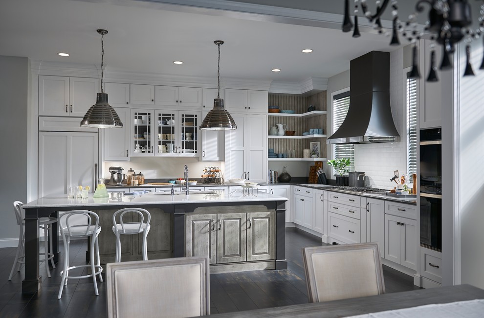 This is an example of an expansive transitional l-shaped open plan kitchen in Minneapolis with flat-panel cabinets, white cabinets, quartz benchtops, white splashback and with island.