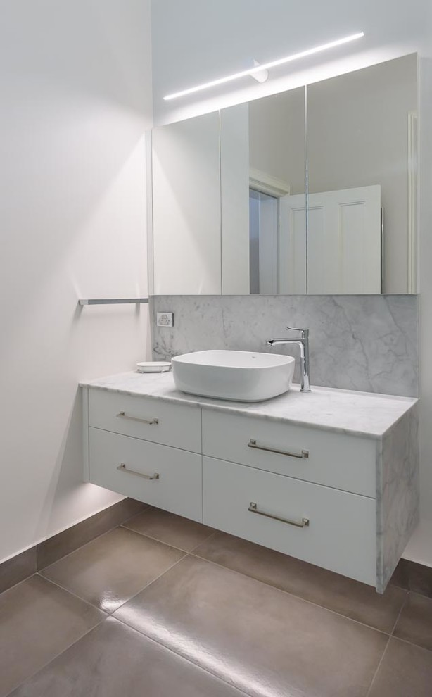 Design ideas for a mid-sized traditional bathroom in Melbourne with flat-panel cabinets, white cabinets, an open shower, a two-piece toilet, white tile, ceramic tile, white walls, porcelain floors, a vessel sink, marble benchtops, grey floor and an open shower.