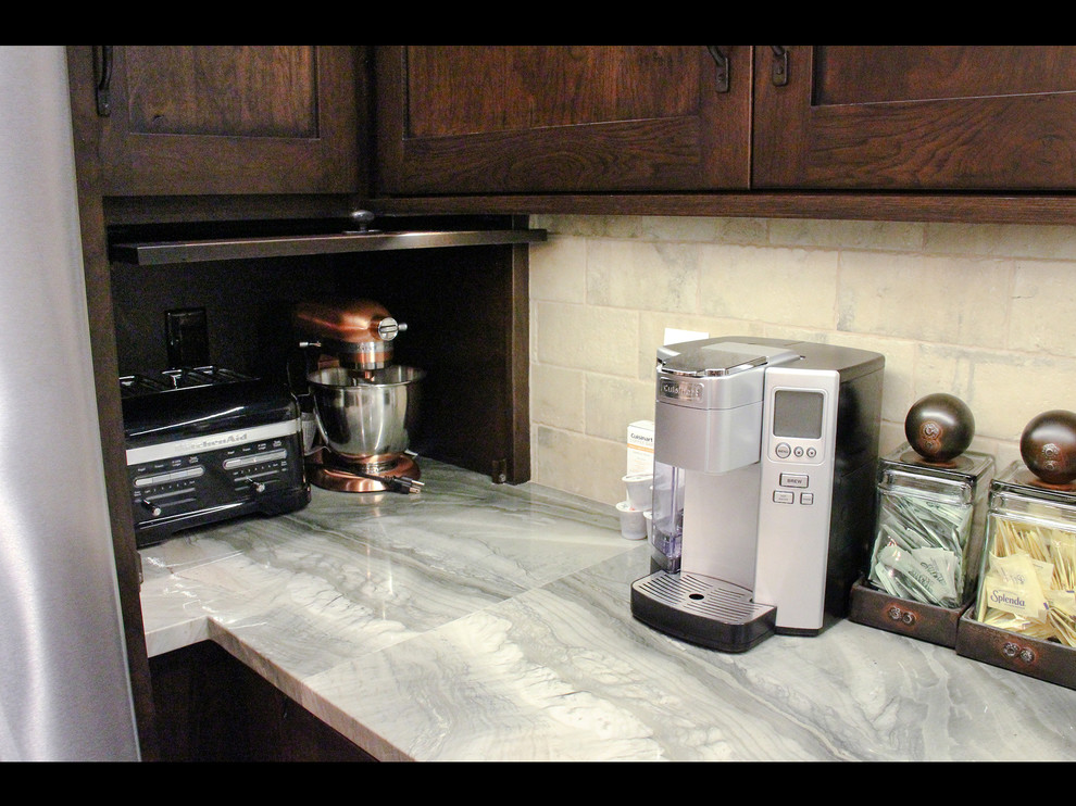 Example of a mountain style galley medium tone wood floor and brown floor open concept kitchen design with shaker cabinets, dark wood cabinets, gray backsplash, gray countertops, an undermount sink, concrete countertops, stainless steel appliances and an island