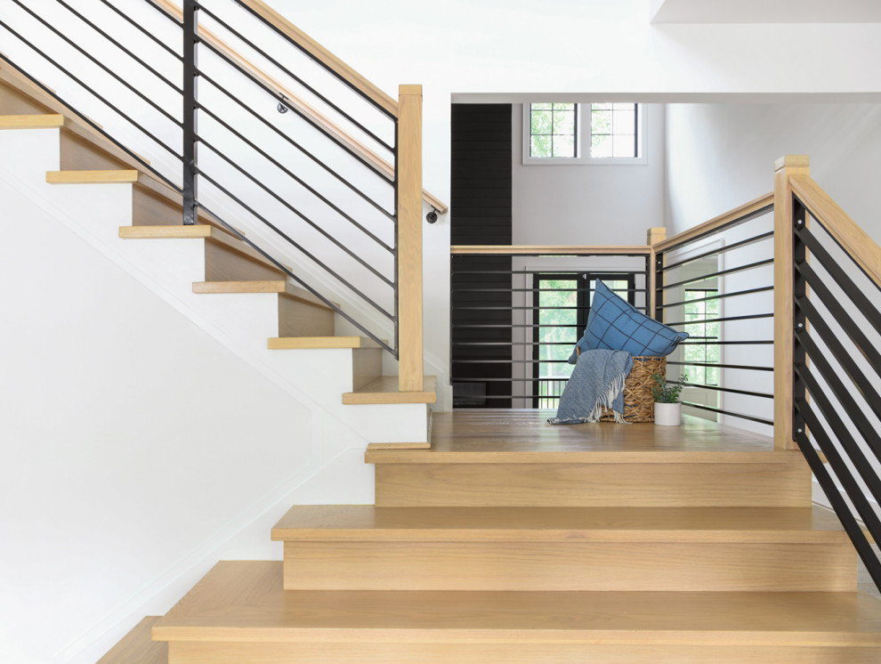 Réalisation d'un escalier design en L de taille moyenne avec des marches en bois, des contremarches en bois et un garde-corps en métal.